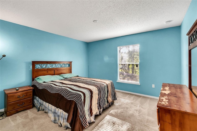 bedroom featuring a textured ceiling and light carpet