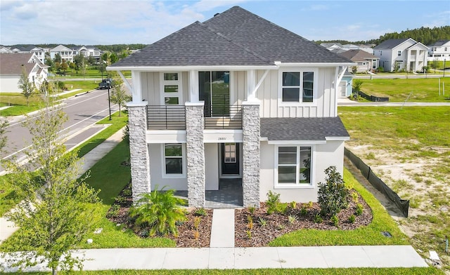 view of front of house with a balcony and a front lawn