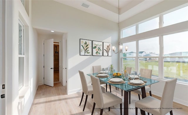 dining area with a chandelier and light hardwood / wood-style flooring