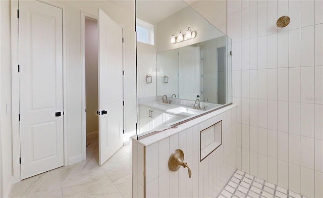 bathroom with a tile shower and sink