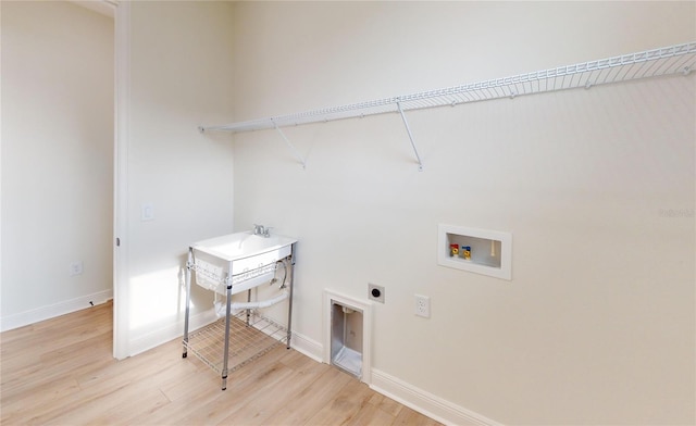 clothes washing area with hookup for an electric dryer, hookup for a washing machine, light hardwood / wood-style flooring, and sink