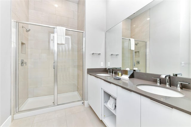 bathroom featuring tile patterned flooring, an enclosed shower, and double vanity