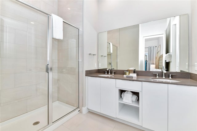 bathroom with double vanity, an enclosed shower, and tile patterned floors