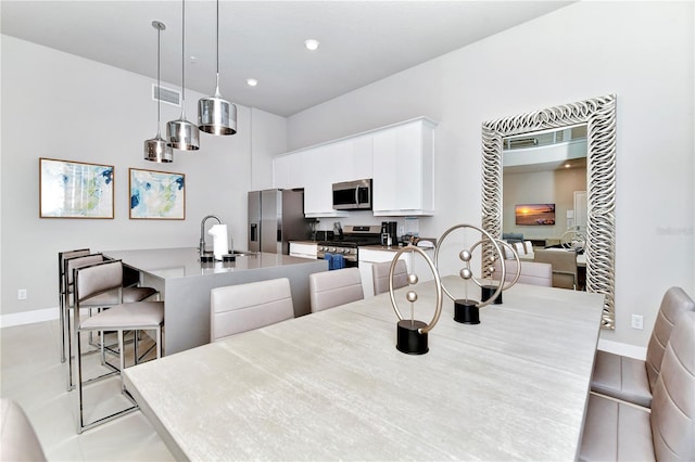 dining space featuring light tile patterned floors and sink