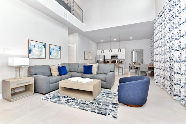 living room with light tile patterned flooring and a towering ceiling