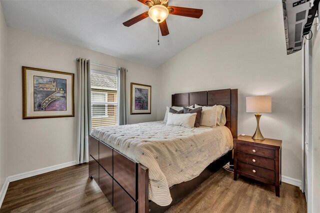 bedroom with ceiling fan, dark hardwood / wood-style flooring, and vaulted ceiling