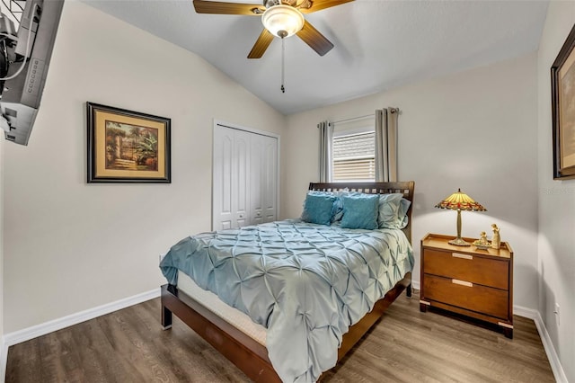 bedroom featuring hardwood / wood-style flooring, lofted ceiling, ceiling fan, and a closet