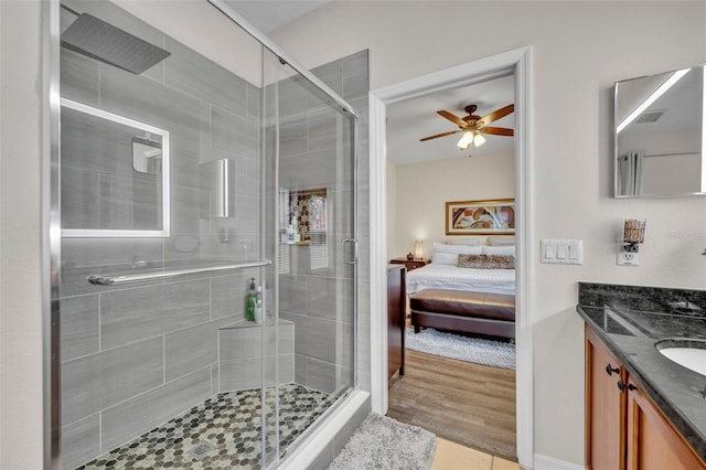 bathroom featuring ceiling fan, vanity, an enclosed shower, and tile patterned flooring