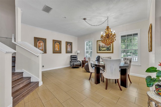 dining room with an inviting chandelier, ornamental molding, and a textured ceiling