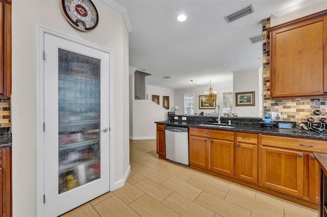 kitchen featuring decorative light fixtures, dishwasher, sink, dark stone countertops, and decorative backsplash