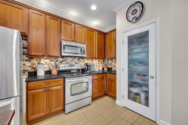 kitchen featuring dark stone countertops, appliances with stainless steel finishes, crown molding, and backsplash