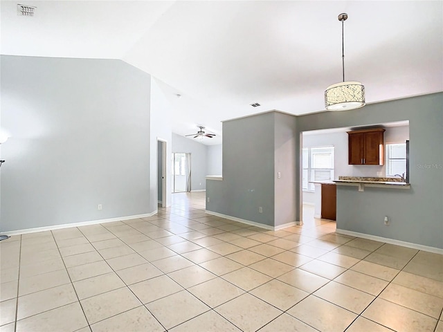 interior space featuring ceiling fan, lofted ceiling, and light tile patterned floors