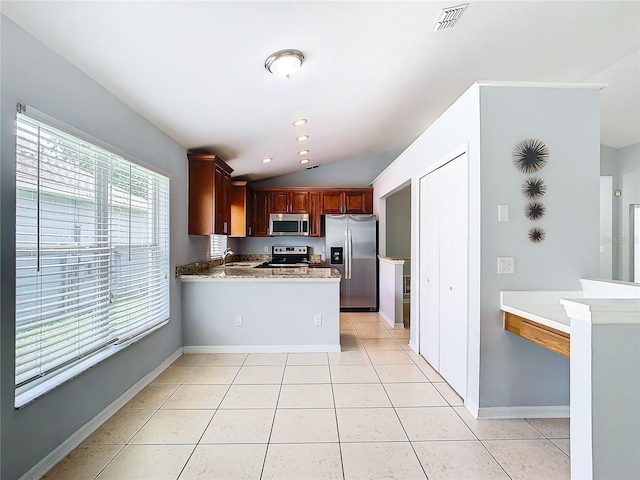 kitchen featuring kitchen peninsula, appliances with stainless steel finishes, vaulted ceiling, sink, and light tile patterned flooring