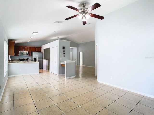 unfurnished living room with ceiling fan, light tile patterned floors, sink, and vaulted ceiling