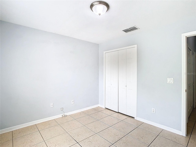 unfurnished bedroom featuring light tile patterned flooring and a closet