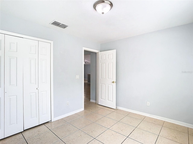 unfurnished bedroom featuring light tile patterned floors and a closet