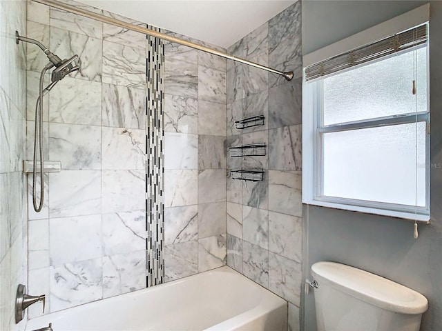 bathroom with tiled shower / bath combo, toilet, and a wealth of natural light