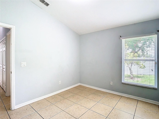 empty room with plenty of natural light and light tile patterned floors