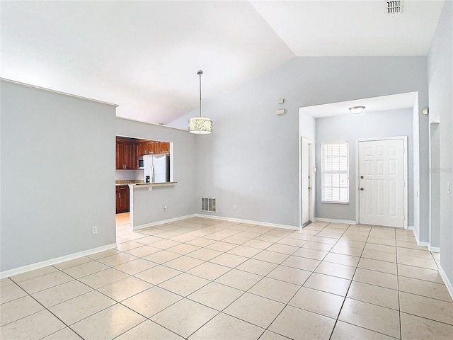 unfurnished living room with light tile patterned floors and vaulted ceiling