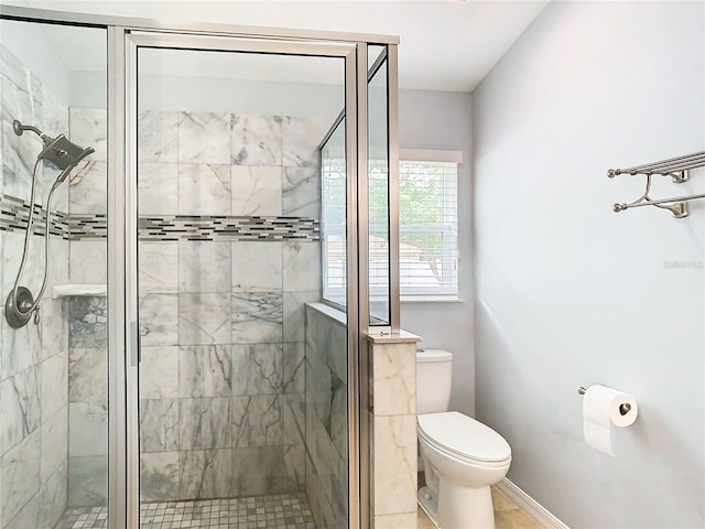 bathroom featuring toilet and a shower with shower door