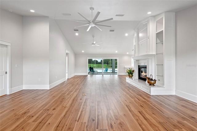 unfurnished living room with ceiling fan, light wood-type flooring, and lofted ceiling