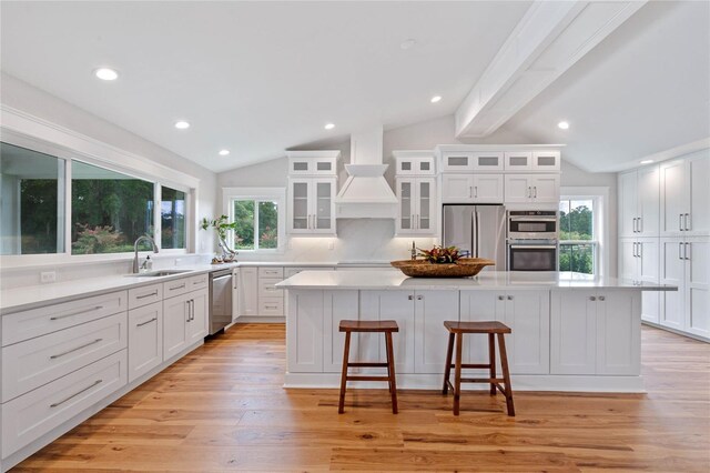 kitchen featuring a center island, white cabinets, sink, appliances with stainless steel finishes, and tasteful backsplash