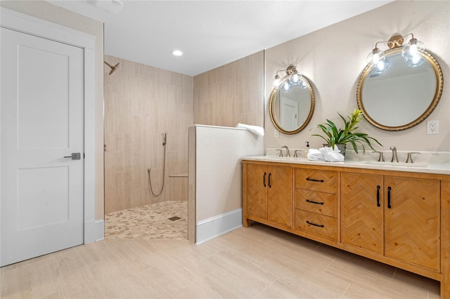 bathroom featuring a tile shower and vanity