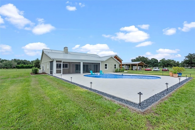 view of pool with a sunroom and a lawn