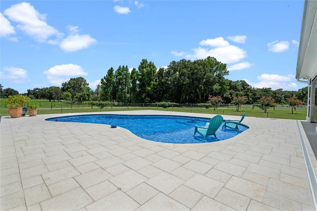 view of swimming pool featuring a lawn and a patio