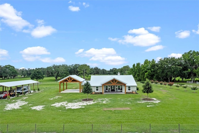 back of property with a carport and a lawn