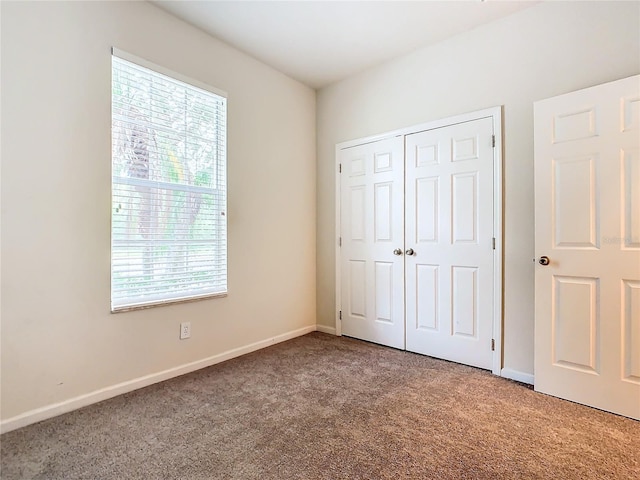 unfurnished bedroom featuring a closet and carpet flooring