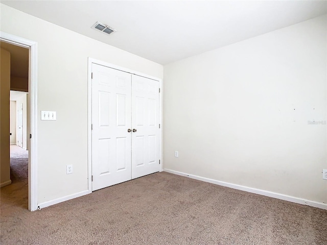 unfurnished bedroom featuring a closet and carpet flooring