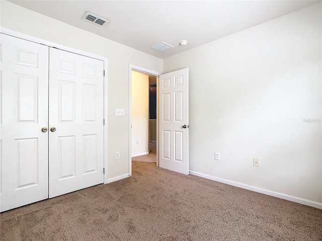 unfurnished bedroom featuring carpet floors and a closet