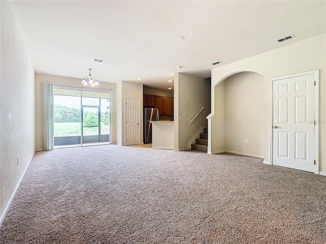 2543 Old Kent Cir, Kissimmee, FL 34758 - unfurnished living room with light carpet, a chandelier, and stairway