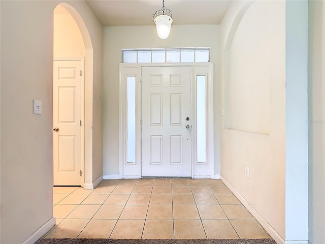 2543 Old Kent Cir, Kissimmee, FL 34758 - foyer entrance featuring light tile patterned floors, arched walkways, and baseboards