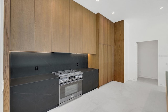 kitchen featuring stainless steel gas range oven and decorative backsplash