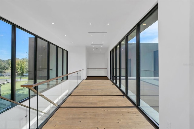 corridor with floor to ceiling windows and wood-type flooring