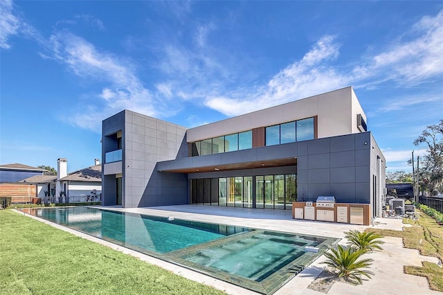 back of property featuring a patio area, a fenced in pool, and area for grilling