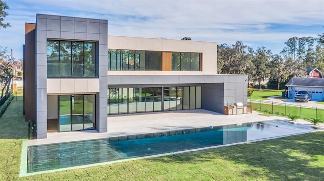 back of house with a yard, a fenced in pool, and a patio area