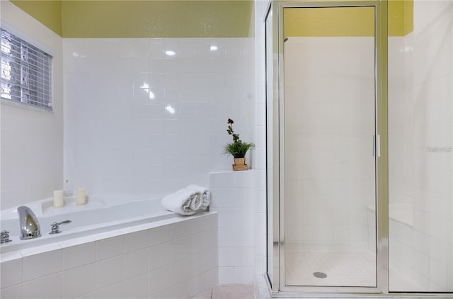 bathroom featuring shower with separate bathtub