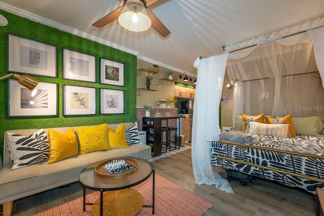 living room with hardwood / wood-style floors, ceiling fan, and crown molding