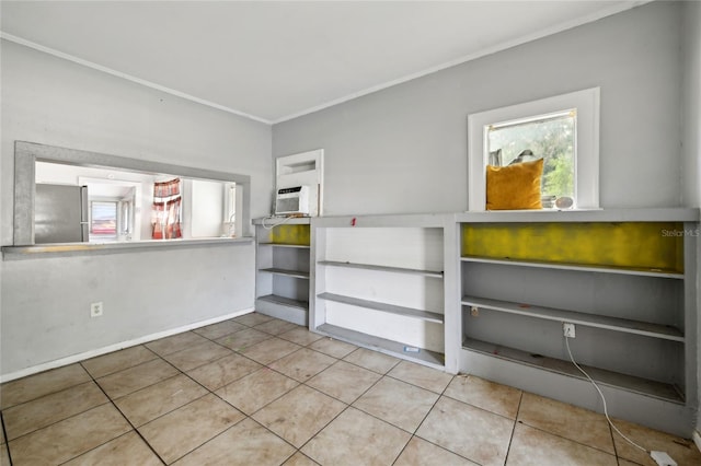 interior space featuring multiple windows, tile patterned floors, and stainless steel refrigerator