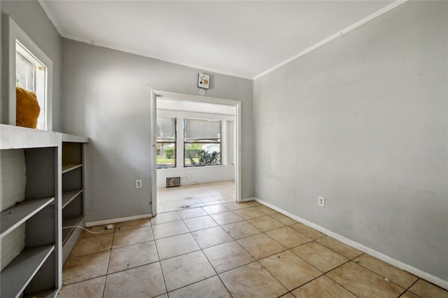 tiled empty room featuring crown molding