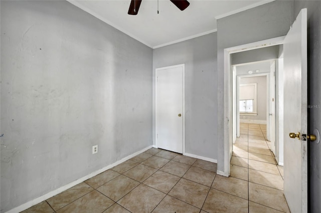 tiled empty room with crown molding and ceiling fan