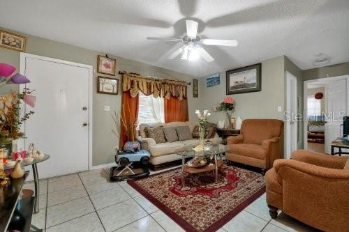 living room featuring light tile patterned flooring and ceiling fan