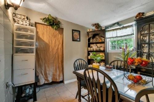 tiled dining room featuring a textured ceiling