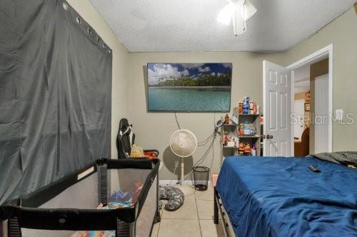 tiled bedroom featuring a textured ceiling