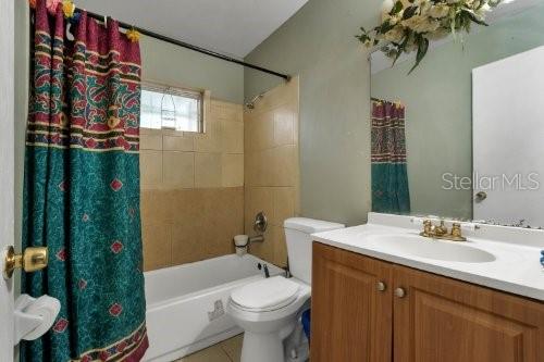 full bathroom with shower / tub combo, vanity, and toilet