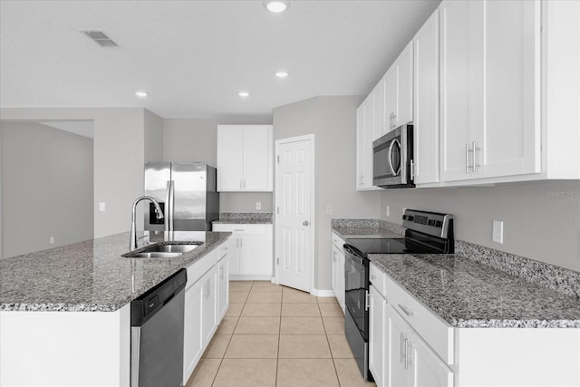 kitchen featuring visible vents, a center island with sink, a sink, appliances with stainless steel finishes, and light tile patterned floors