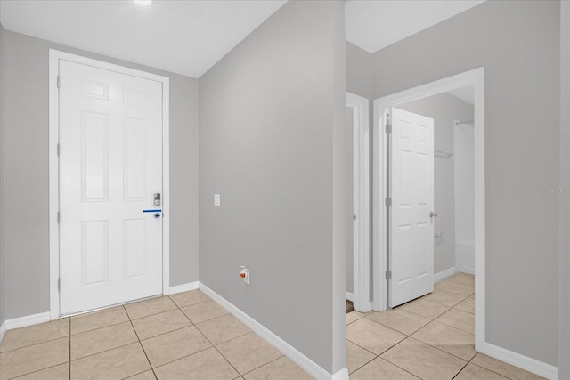 hall with light tile patterned floors and baseboards